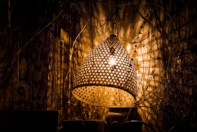 A pastoral woven wall lamp illuminating a textured wall, adding a touch of nature indoors.