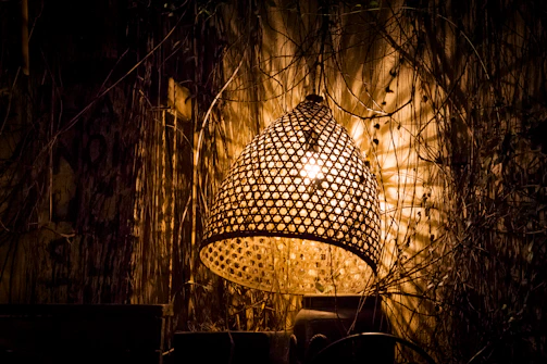 A cozy nook illuminated by a rustic bohemian lantern casting golden light onto woven baskets and natural textiles.