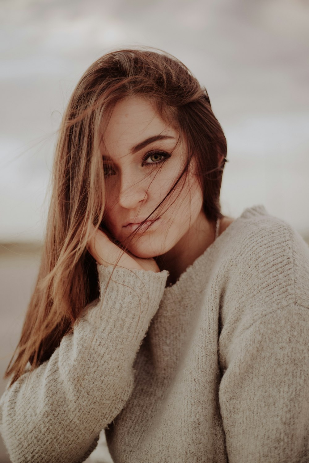 woman in gray sweater taking selfie