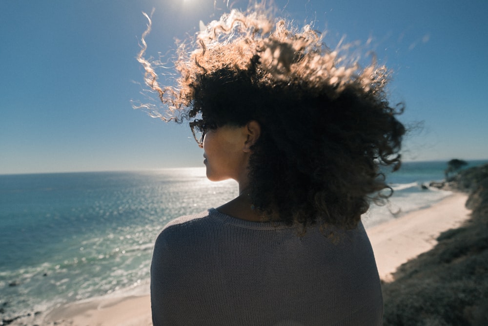 woman wearing gray shirt overlooking at ocean