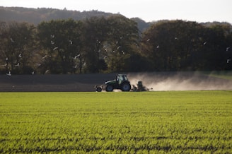 black tractor on green fields during daytime
