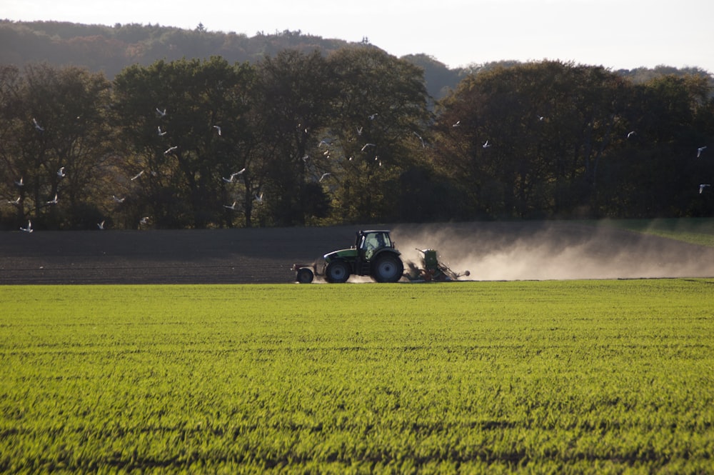 black tractor on green fields during daytime