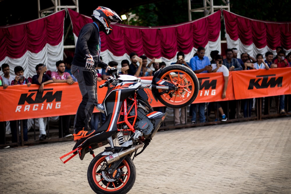 man doing tricks while riding on dirt bike