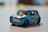 Close-up of a gleaming diecast car prize held proudly by a smiling winner.