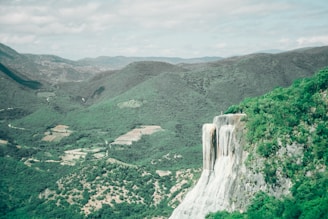 A scenic view of emerald mines surrounded by lush green hills.