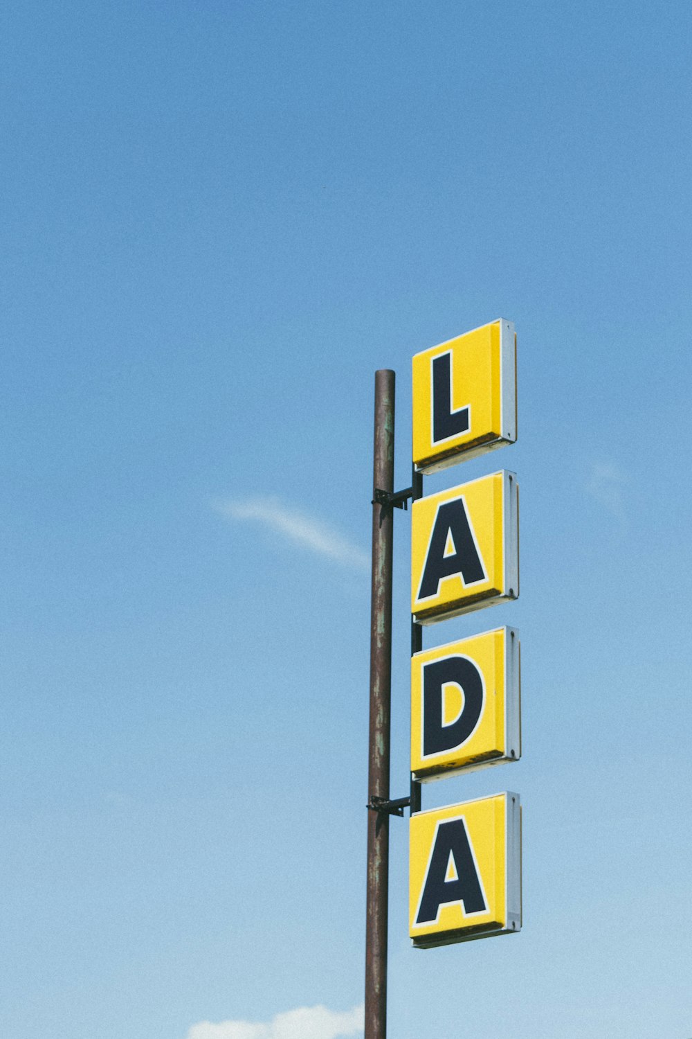 yellow and black lada signage under blue sky