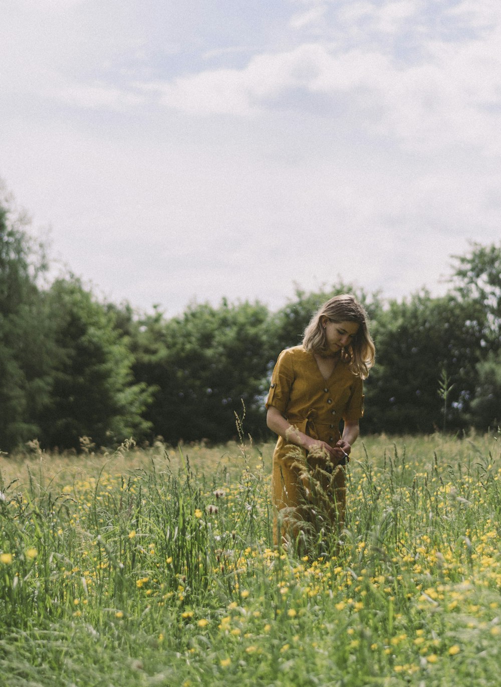 woman wearing brown V-neck dress standing on the flower field