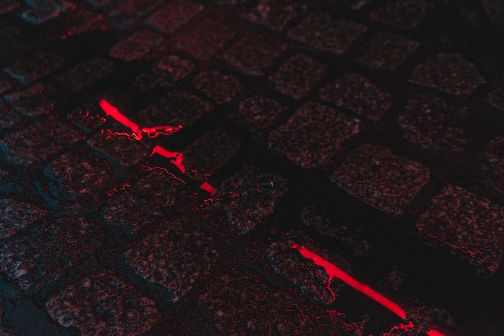 a close up of a brick wall with red light