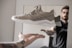 person showing unpaired gray and white running shoe