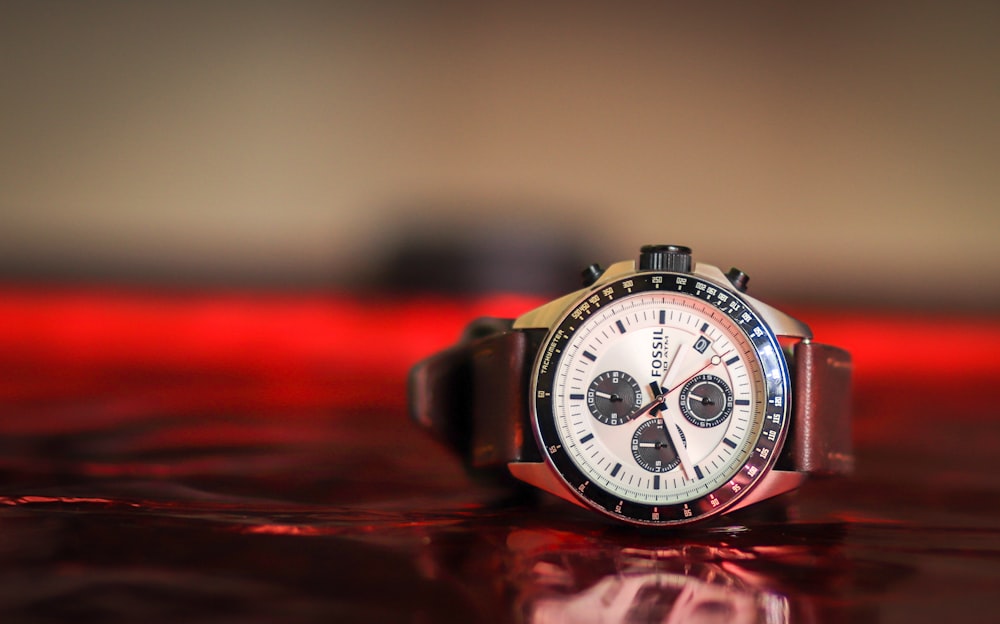 relógio cronógrafo fóssil redondo preto e branco com pulseira de couro marrom exibido às 10:42
