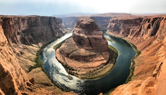 A serene view of the horseshoe-shaped bend in the Strawberry River surrounded by lush Ozark foothills under a clear blue sky.