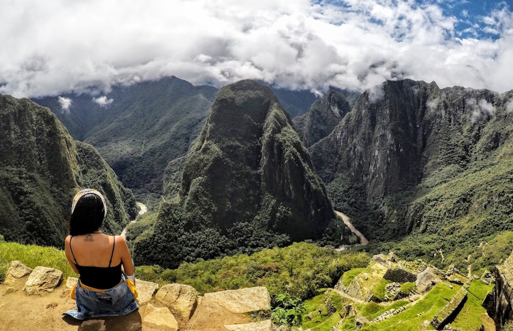 woman sitting on rock during daytime