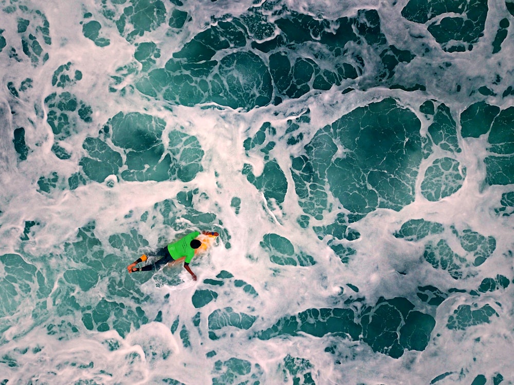 high-angle photography of man riding on surfboard