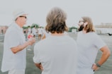 A group of friends in casual urban wear hanging out on a rooftop at sunset.