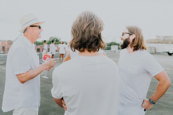 A group of friends in casual athleisure wear laughing together on a rooftop.
