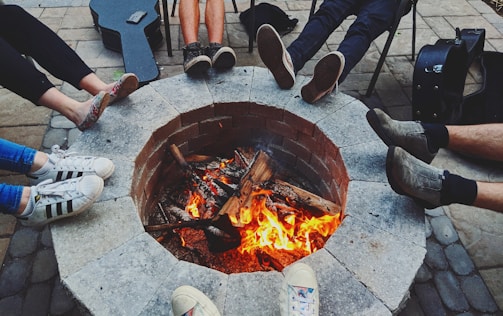 A group of friends enjoying a bonfire with acoustic music in the countryside.