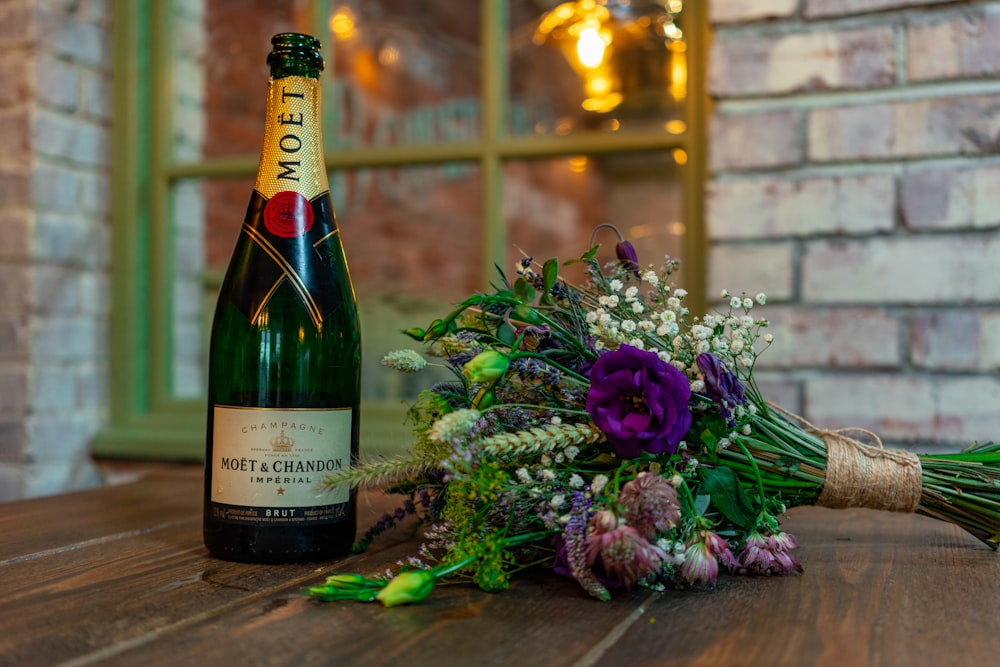 Moet bottle beside bouquet on table