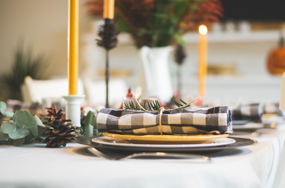 Taschentuch auf dem Teller neben Kerzen auf dem Tisch