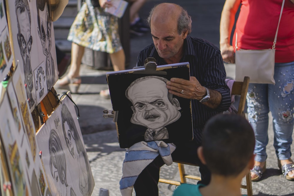 artista sosteniendo un retrato