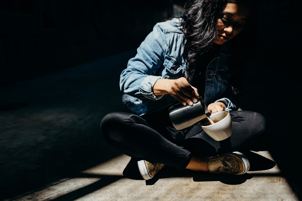 woman pouring a liquid into white ceramic cup