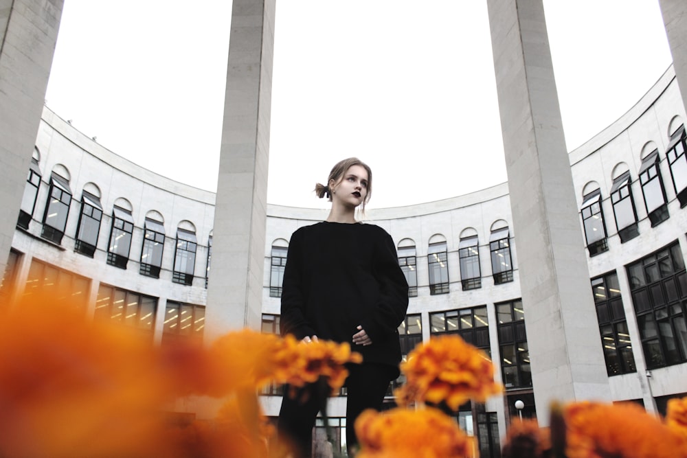 low angle photo of woman standing beside building