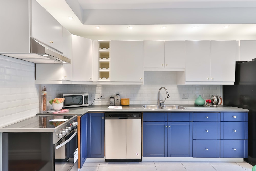 eine Küche mit blauen Schränken und einem schwarzen Kühlschrank