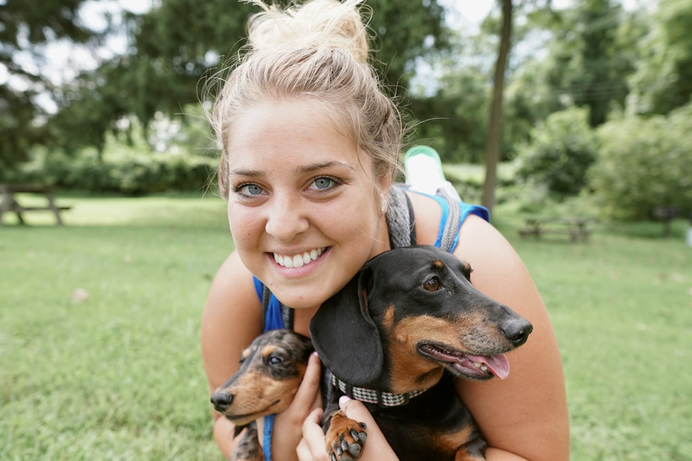 woman carrying two puppies