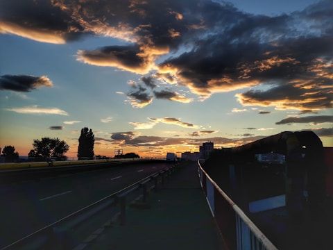 Moody black-and-white shot of a desert highway at dusk, capturing fading light and a lone vintage pickup truck.