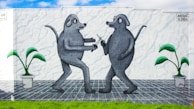 A mural depicts two anthropomorphic, gray dog-like figures facing each other on a white textured wall. Each has a tail and a cartoonish appearance. One figure holds a tool, possibly a paintbrush or a pen. On either side of the figures, potted plants with green leaves and white pots are placed. The ground is tiled in a gray and black checkered pattern, bordered by green grass at the bottom.