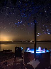 A sleek, modern hot tub glowing softly in a cozy outdoor setting at dusk.