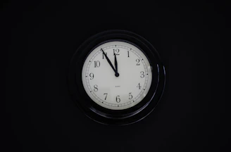 Close-up of a classic round wall clock with bold black numbers against a white face.