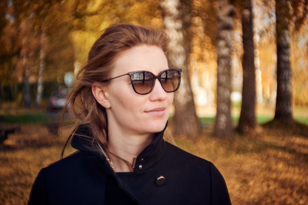 woman in black shirt standing under tree