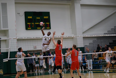 A vibrant action shot of the ASD Leinì VBC team in light blue and yellow uniforms during a thrilling volleyball match.