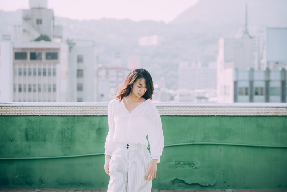 woman standing near green wall during daytime