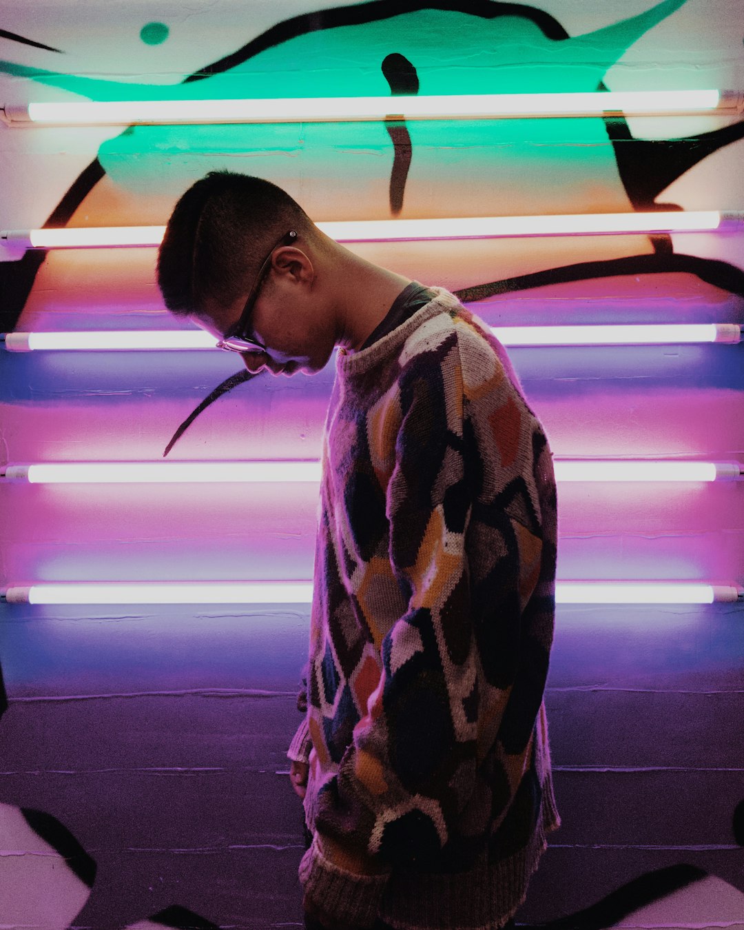 man standing beside lighted wall