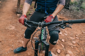 Close-up of a cyclist wearing high-elastic wrist and ankle supports on a mountain trail