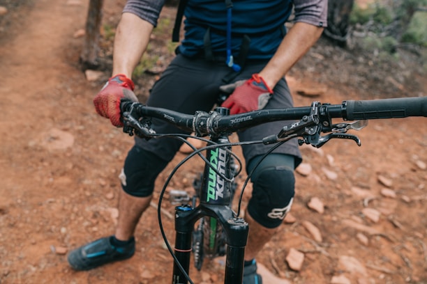 a man riding a bike down a dirt road