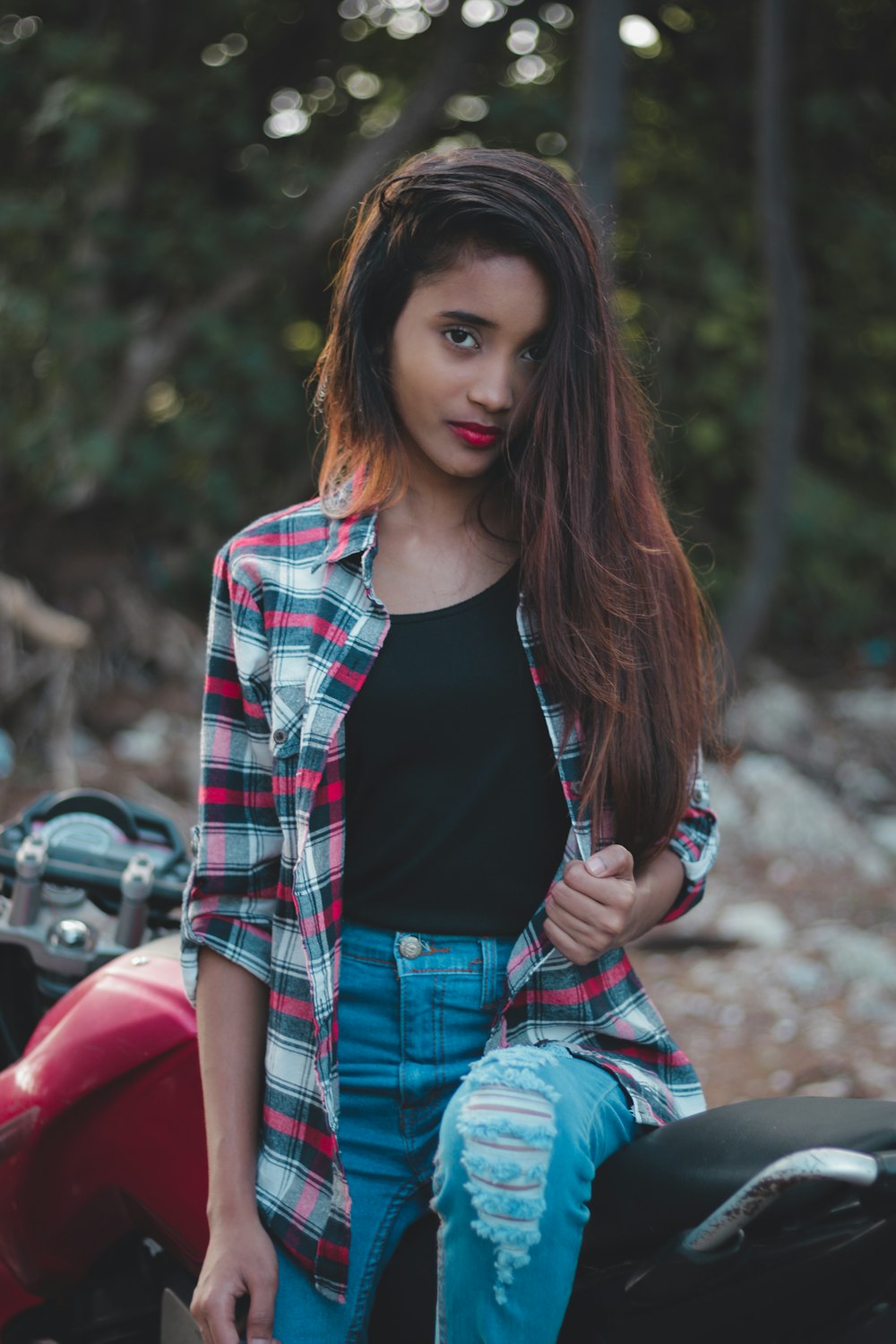 woman sitting on red and black standard motorcycle