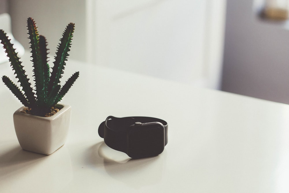turned-off Apple Watch beside cactus plant on table