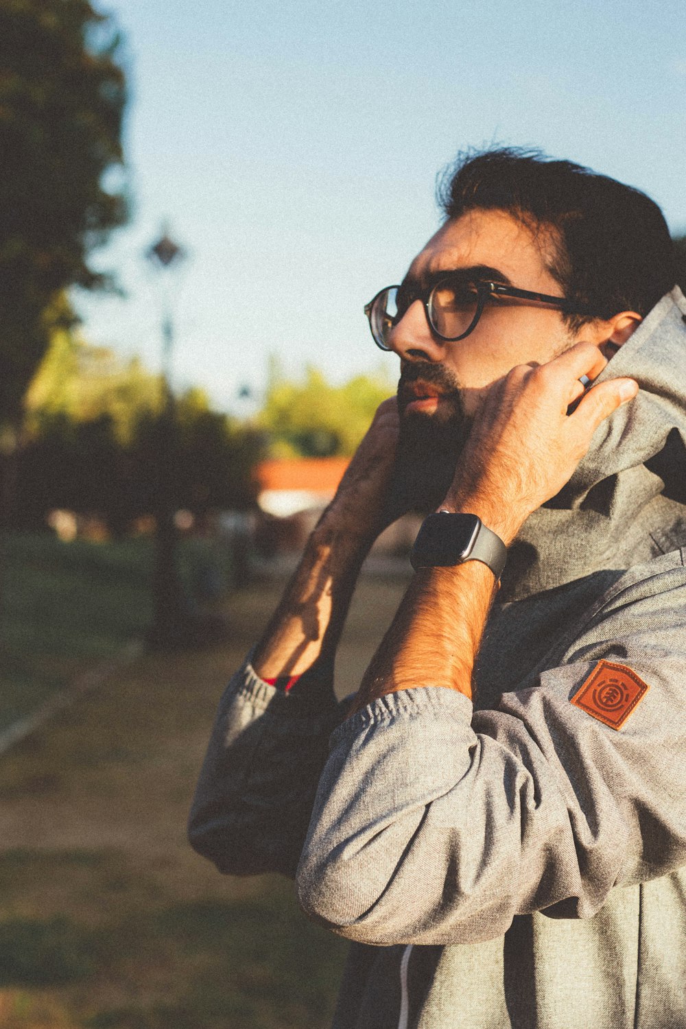 man wearing black framed eyeglasses fixing hood