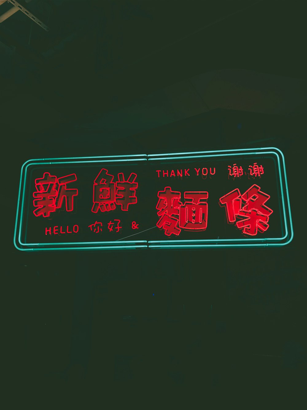 ありがとうとこんにちはのネオンサインが入った赤い漢字テキスト
