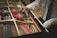Close-up of a piano technician carefully tuning piano strings with a tuning hammer.