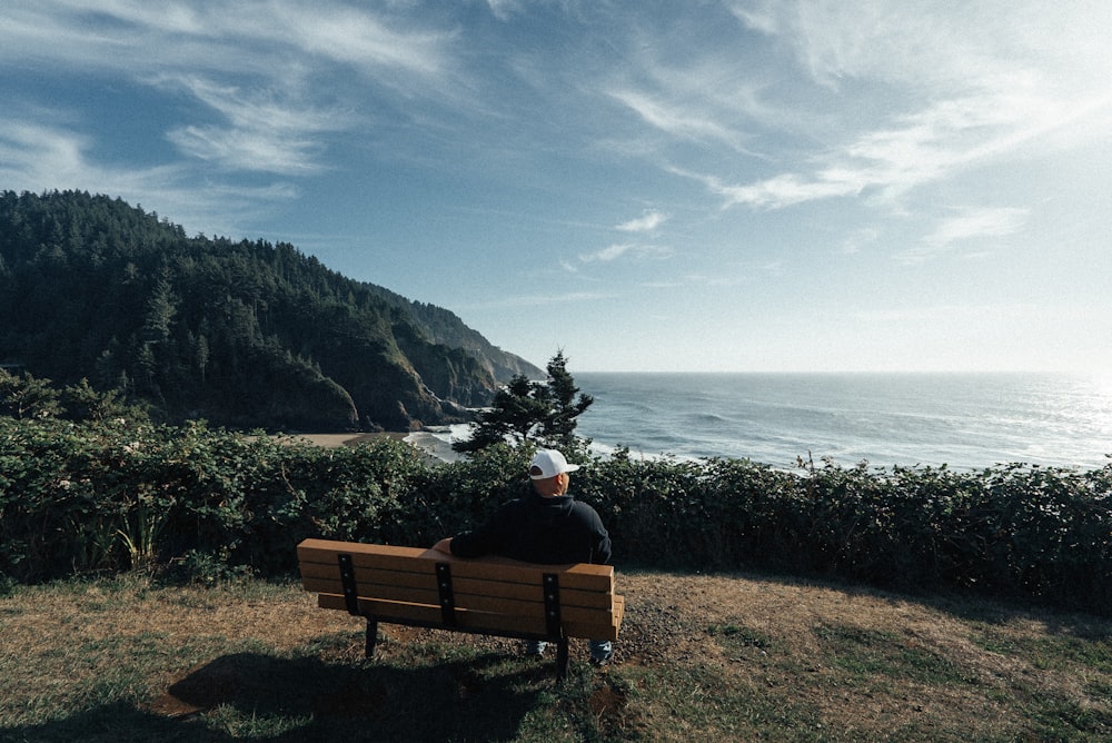 man sitting on bench with mountain background