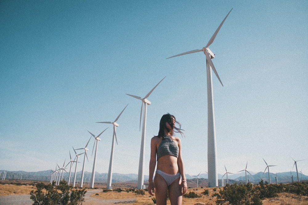 woman standing in front of white windmills