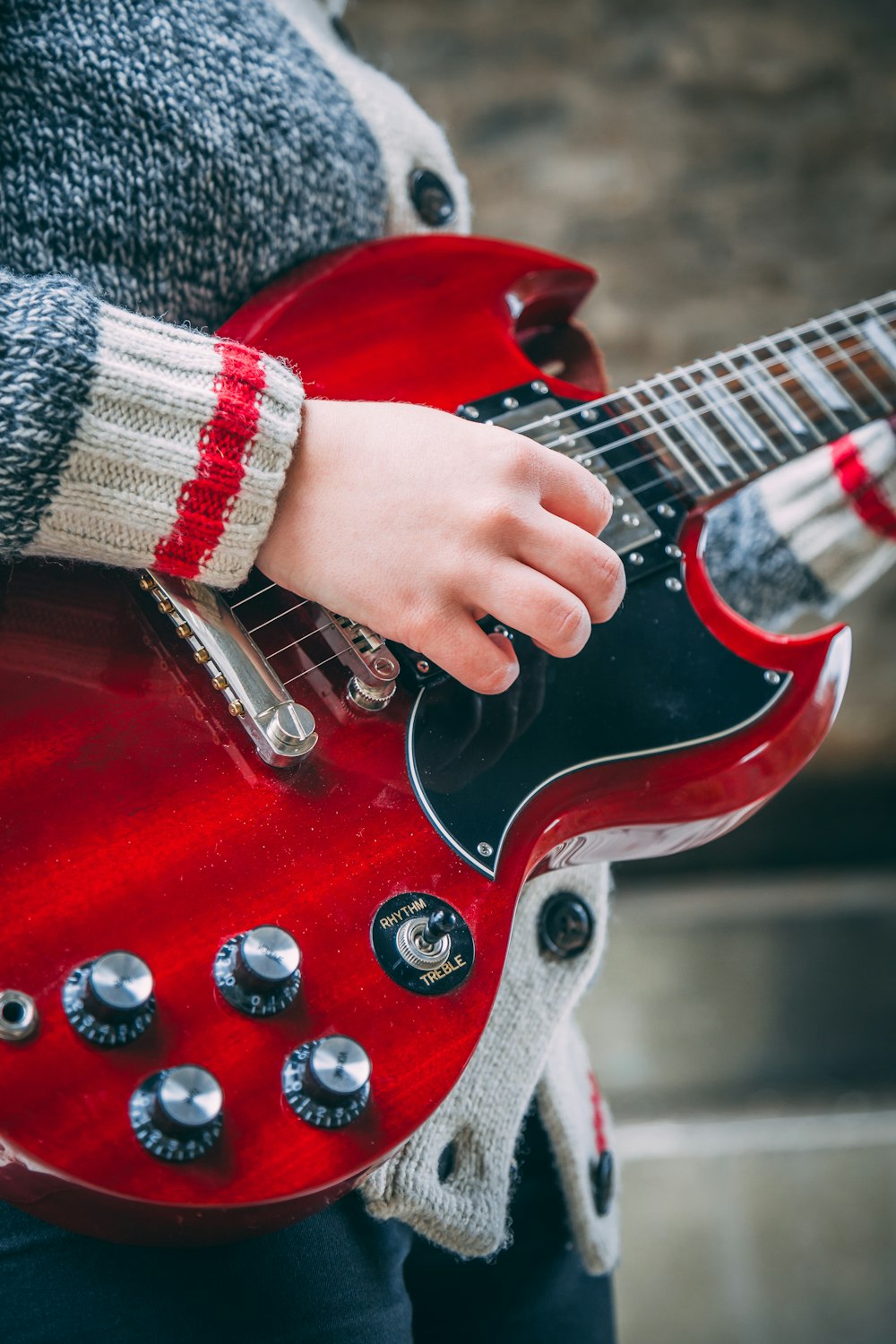 person playing red SG guitar