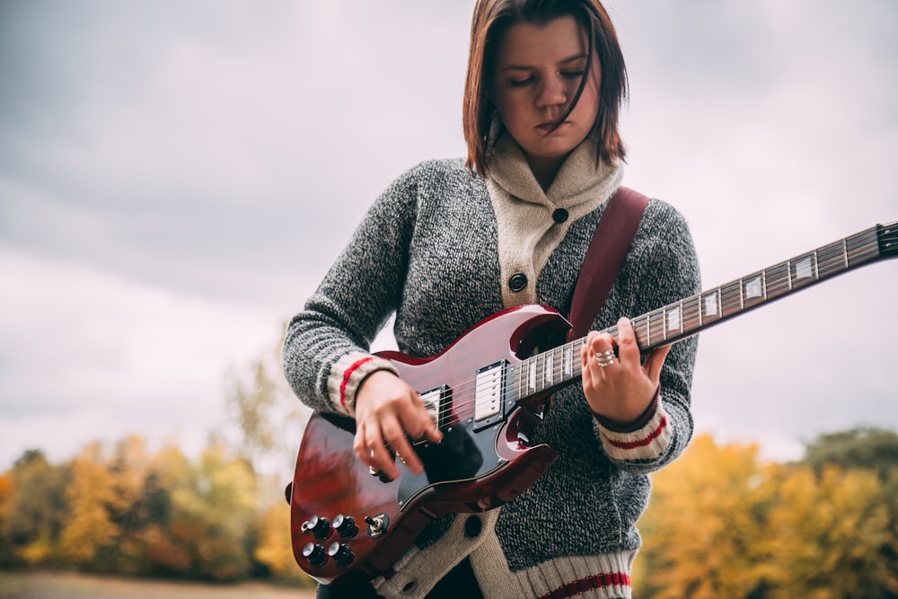 woman playing guitar during daytime