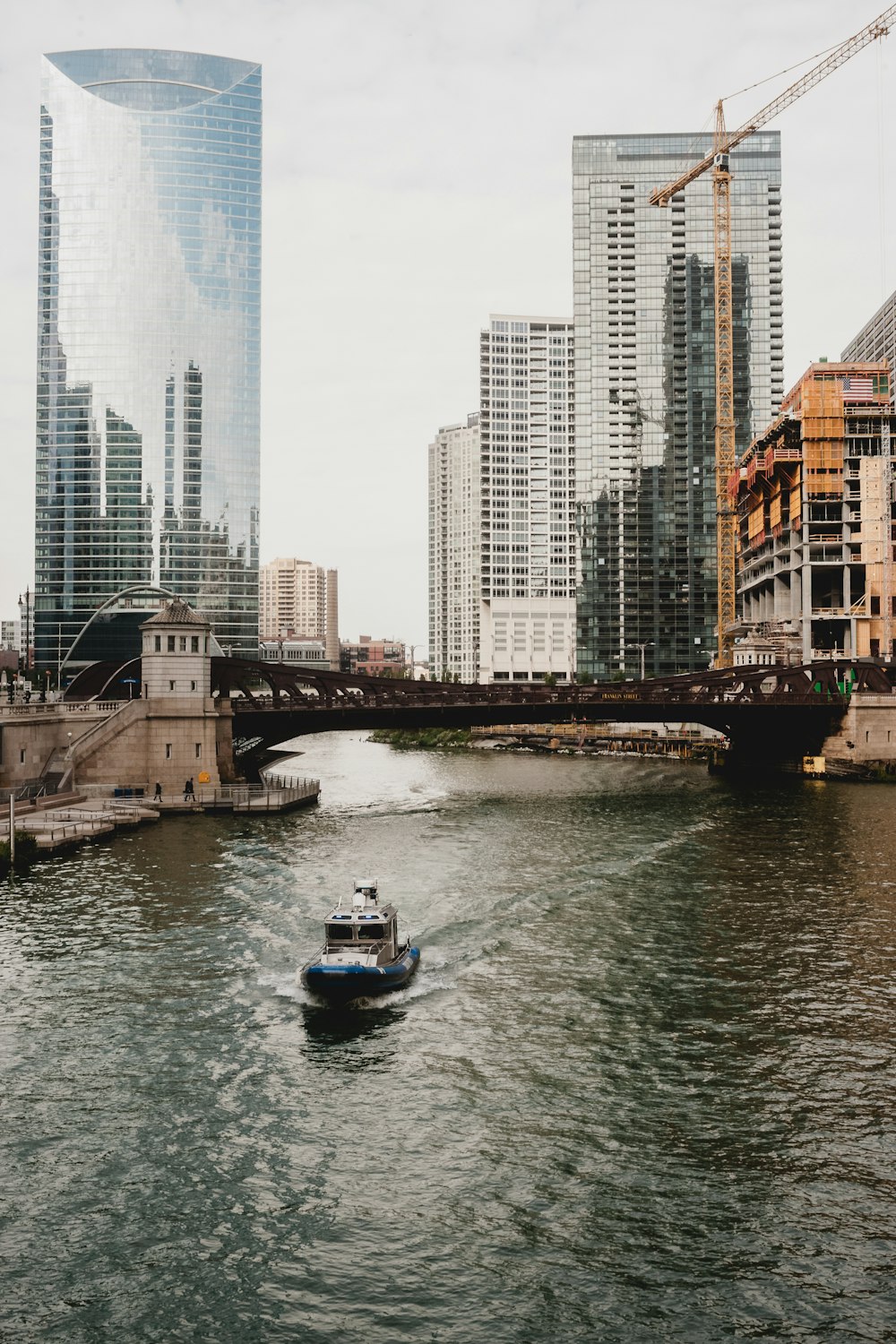 a boat traveling down a river next to tall buildings