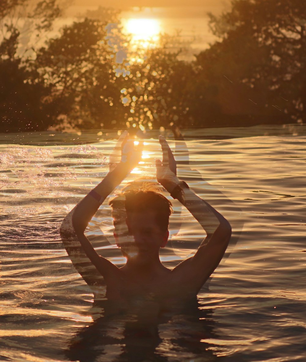 man swimming in body of water