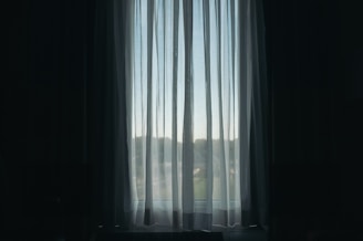 Sheer curtains gently filtering sunlight in a bright, airy room.