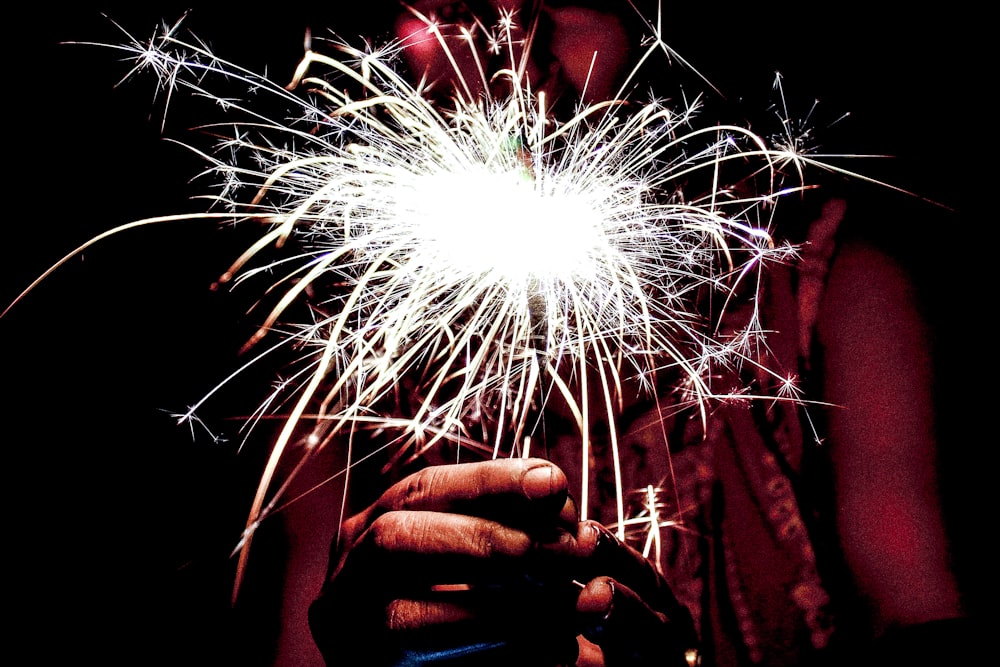 person holding fire sparkle